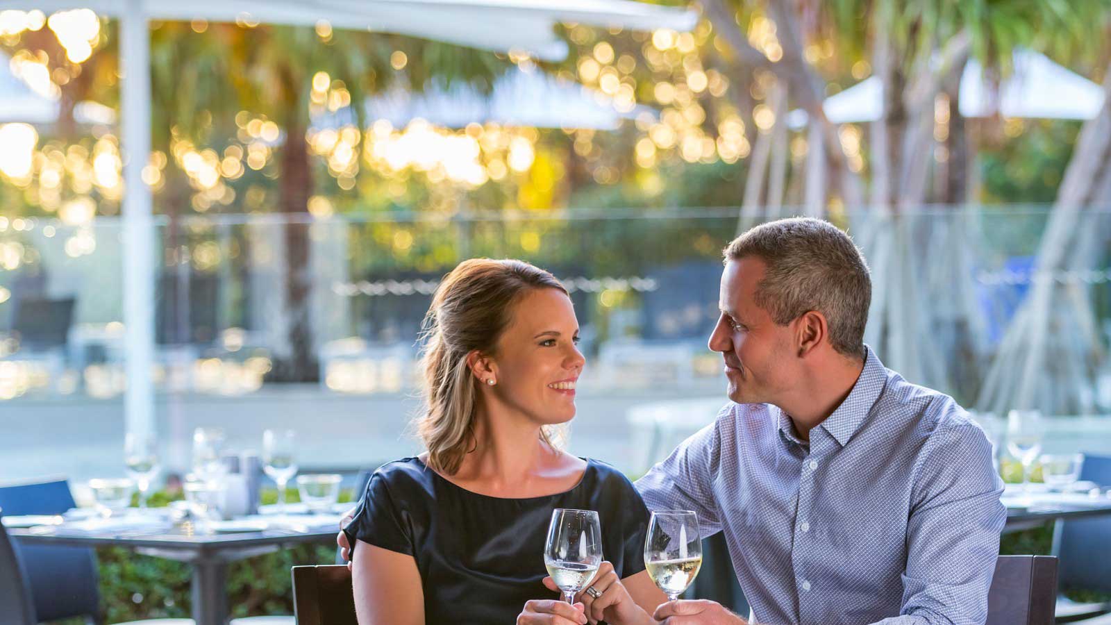Noosa couple dining outdoors by the pool