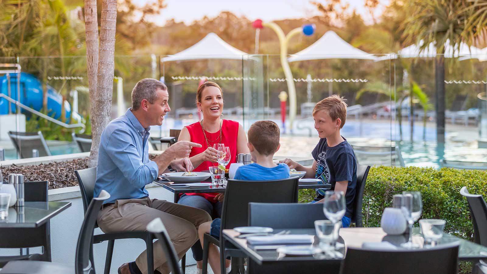 Family dining together outdoors by the pool