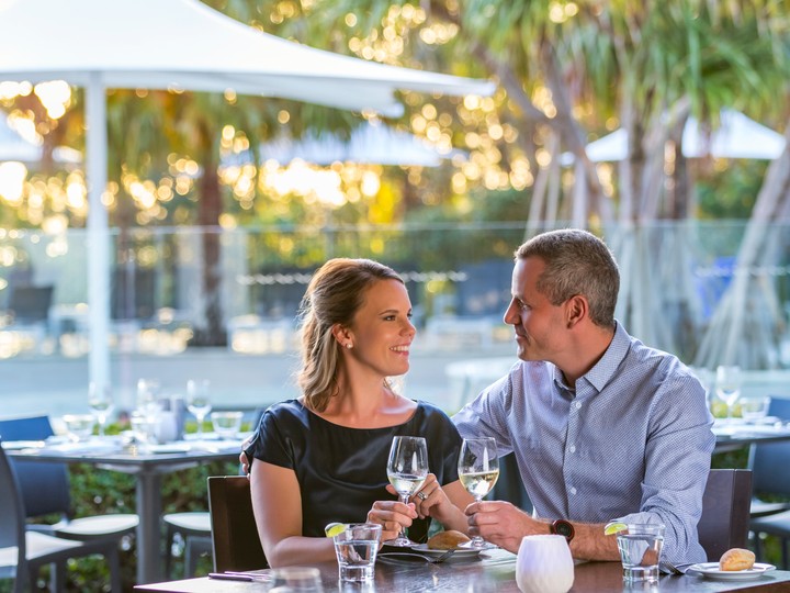 Noosa couple dining outdoors by the pool