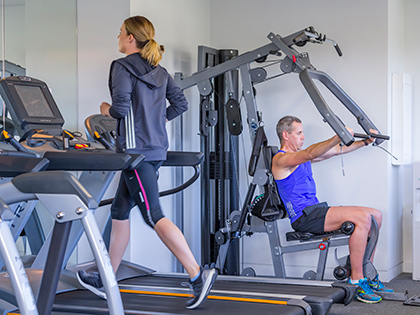 Two people using the gym facilities at RACV Noosa Resort.