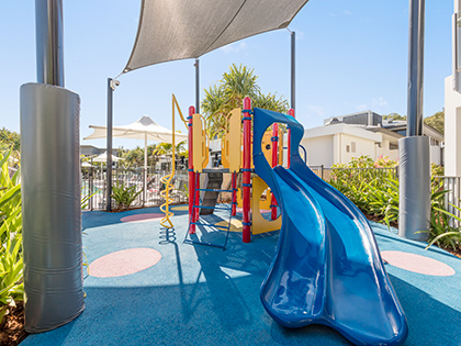 Outdoor undercover playground at RACV Noosa Resort, with two blue slides.