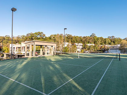 Outdoor grass tennis court at RACV Noosa Resort, with floodlights.