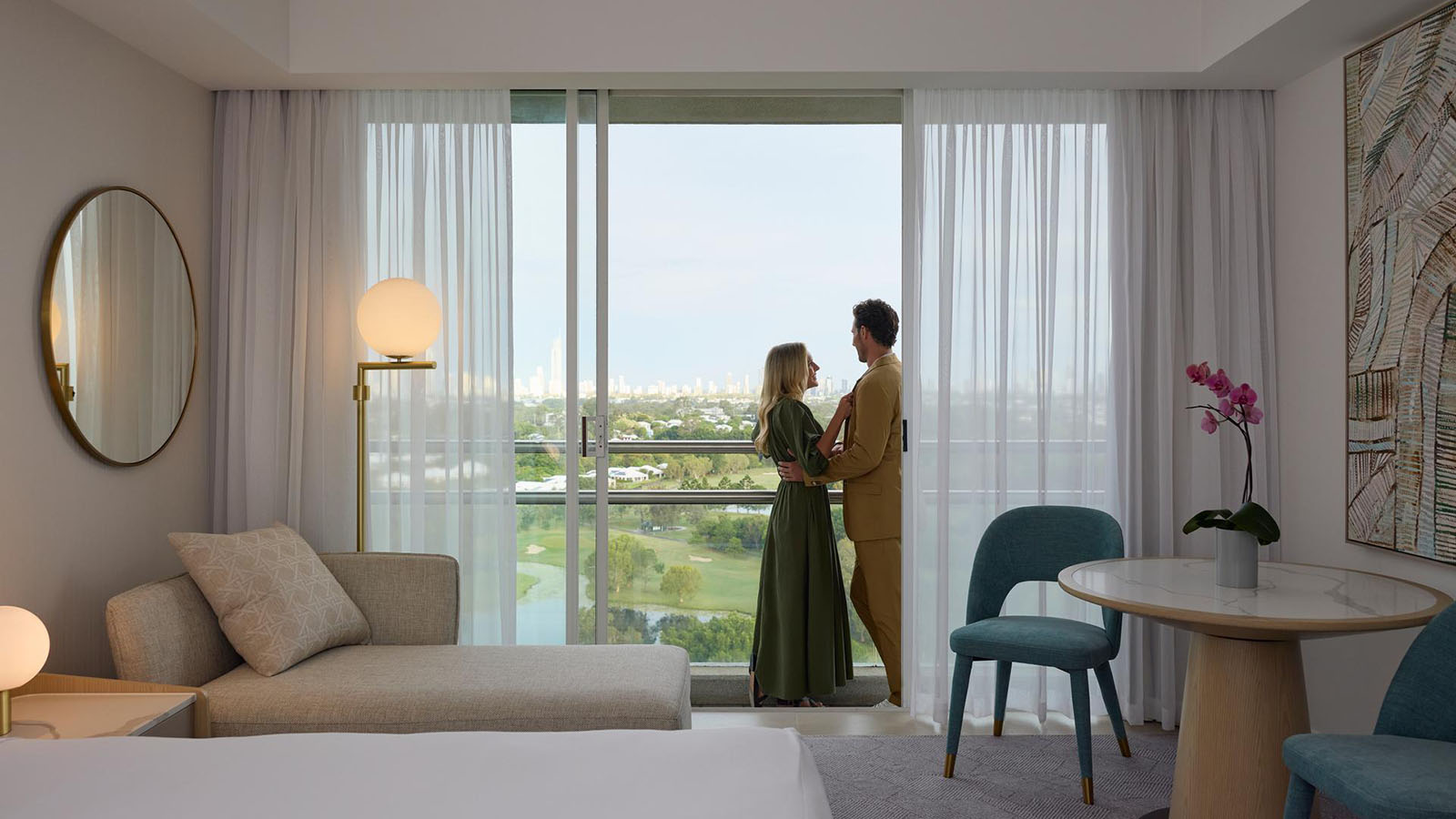 Couple standing together on balcony of Superior Room at RACV Royal Pines.