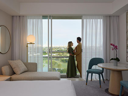 Couple standing together on balcony of Superior Room at RACV Royal Pines.