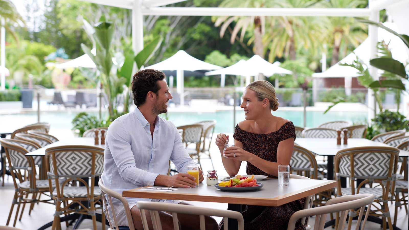 A couple eating breakfast outside. 