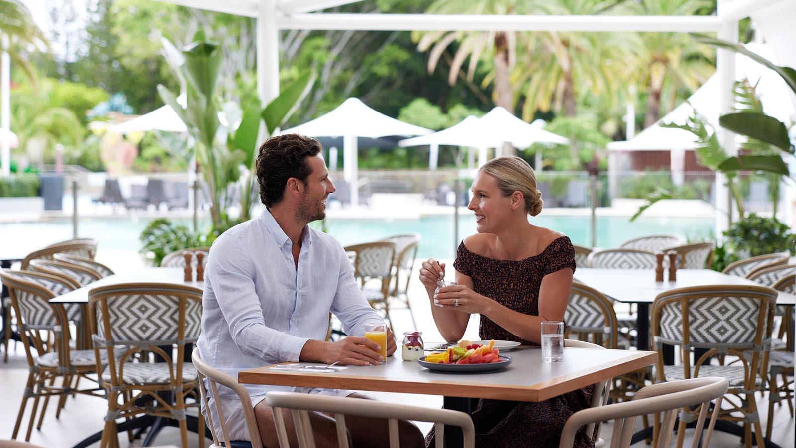 Couple dining poolside at RACV Royal Pines Kalinda restaurant.