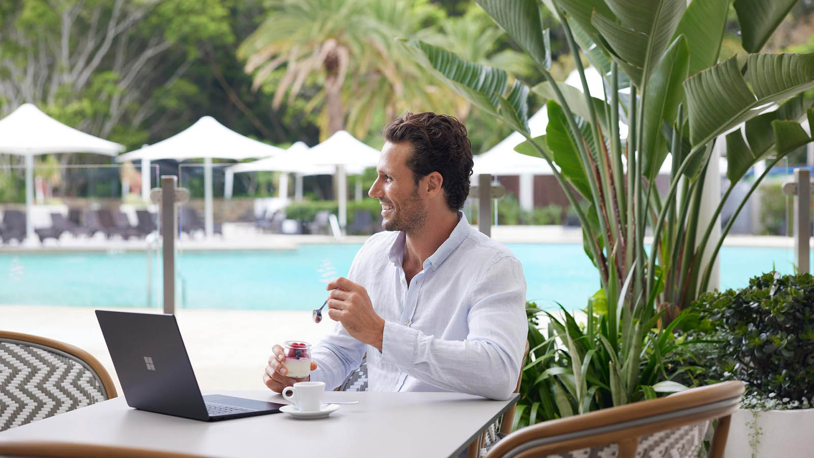 Man enjoying breakfast and coffee poolside at RACV Royal Pines Kalinda restaurant.