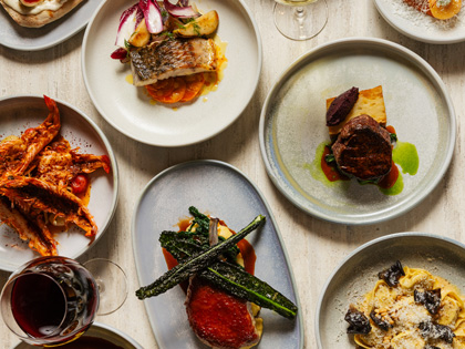 Various different dishes and a glass of wine