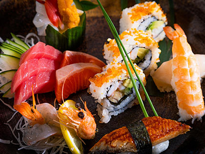 Plate featuring a variety of sashimi, sushi rolls and nigiri.