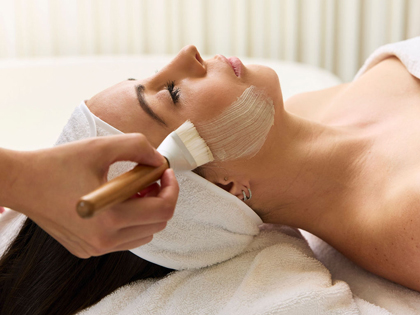 Woman having a face mask brusked onto her cheek.