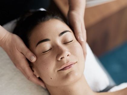 Close up of a woman's face enjoying a facial treatment.