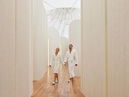 Couple holding hands and walking at the RACV Royal Pines Resort One Spa facility.