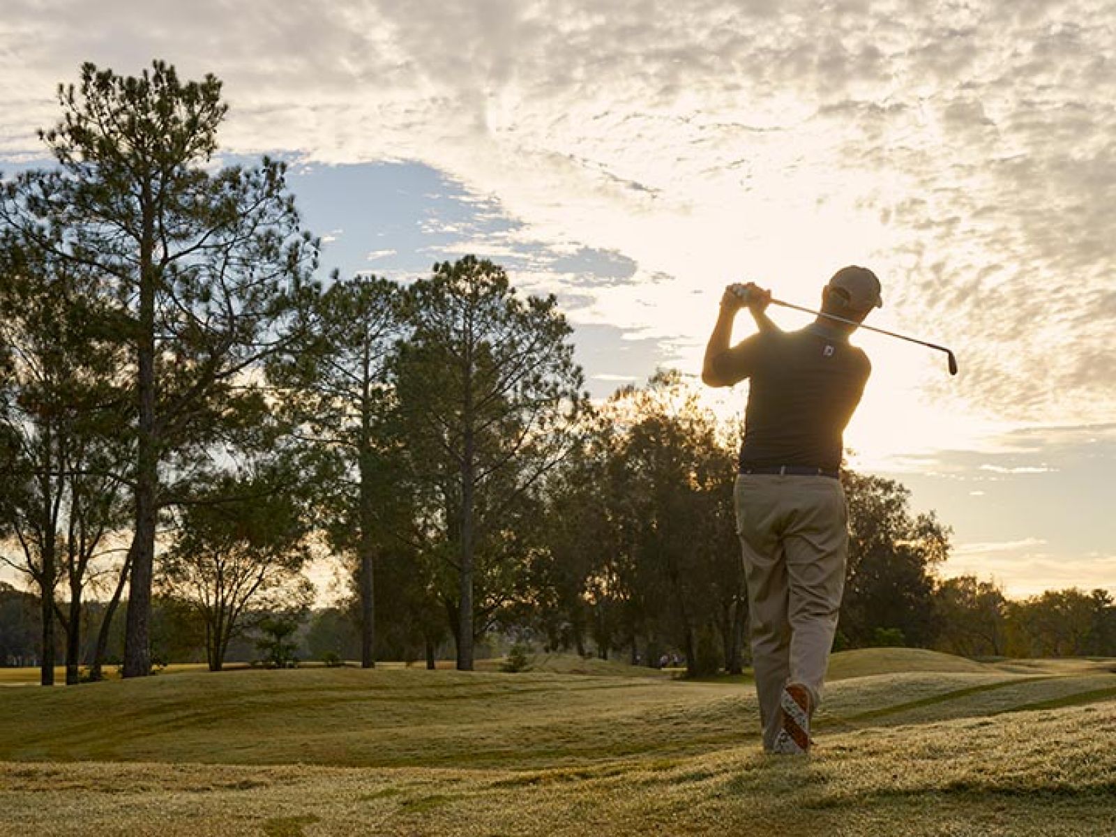 Person swinging golf club at RACV Royal Pines Resort.