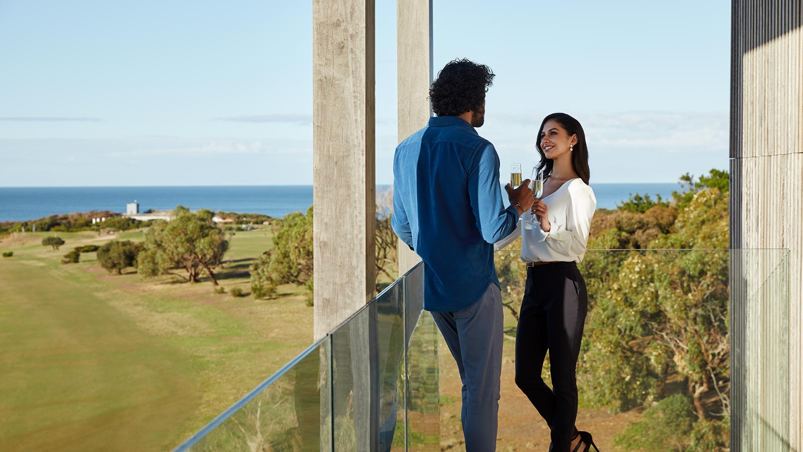 Couple having a drink on the balcony of their room at RACV Torquay Resort.
