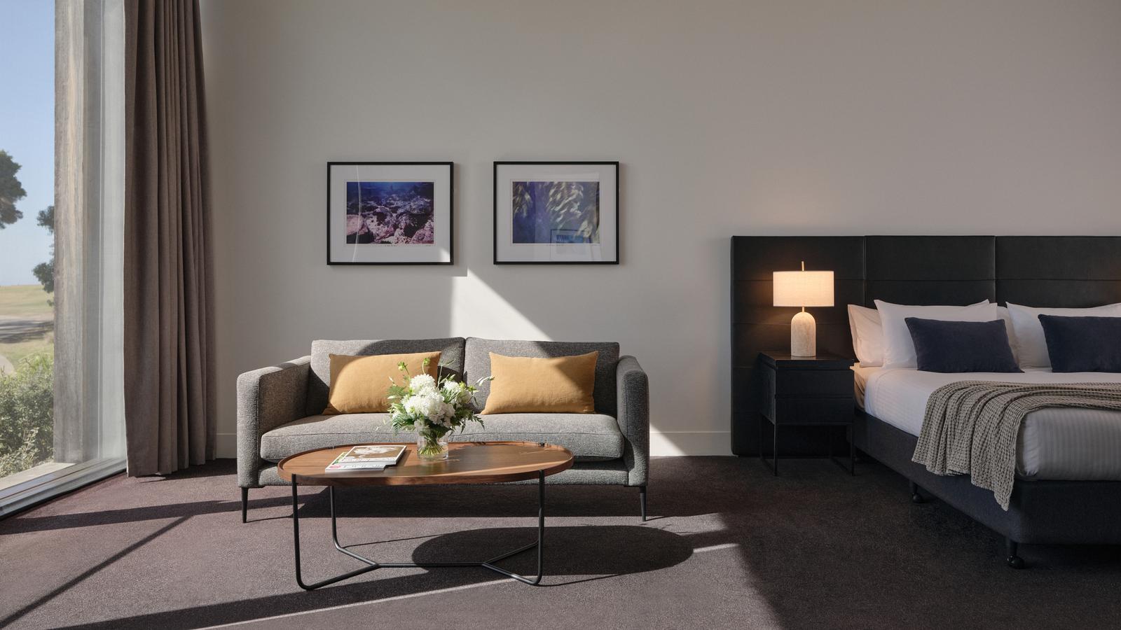 Golf view room at RACV Torquay Resort, featuring a king bed, couches and desk.