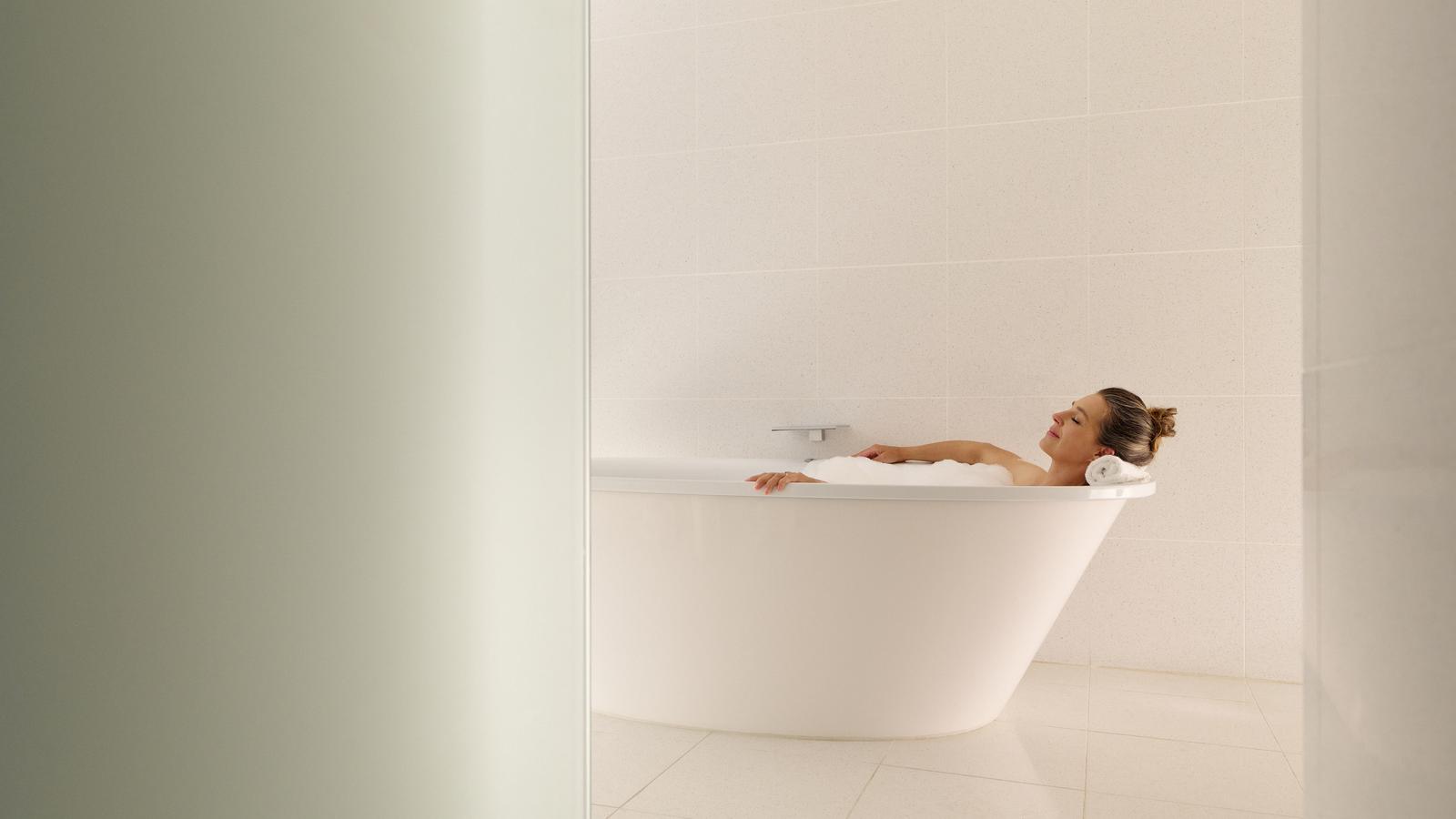 Woman soaking in the ocean spa suite bathtub RACV Torquay Resort.