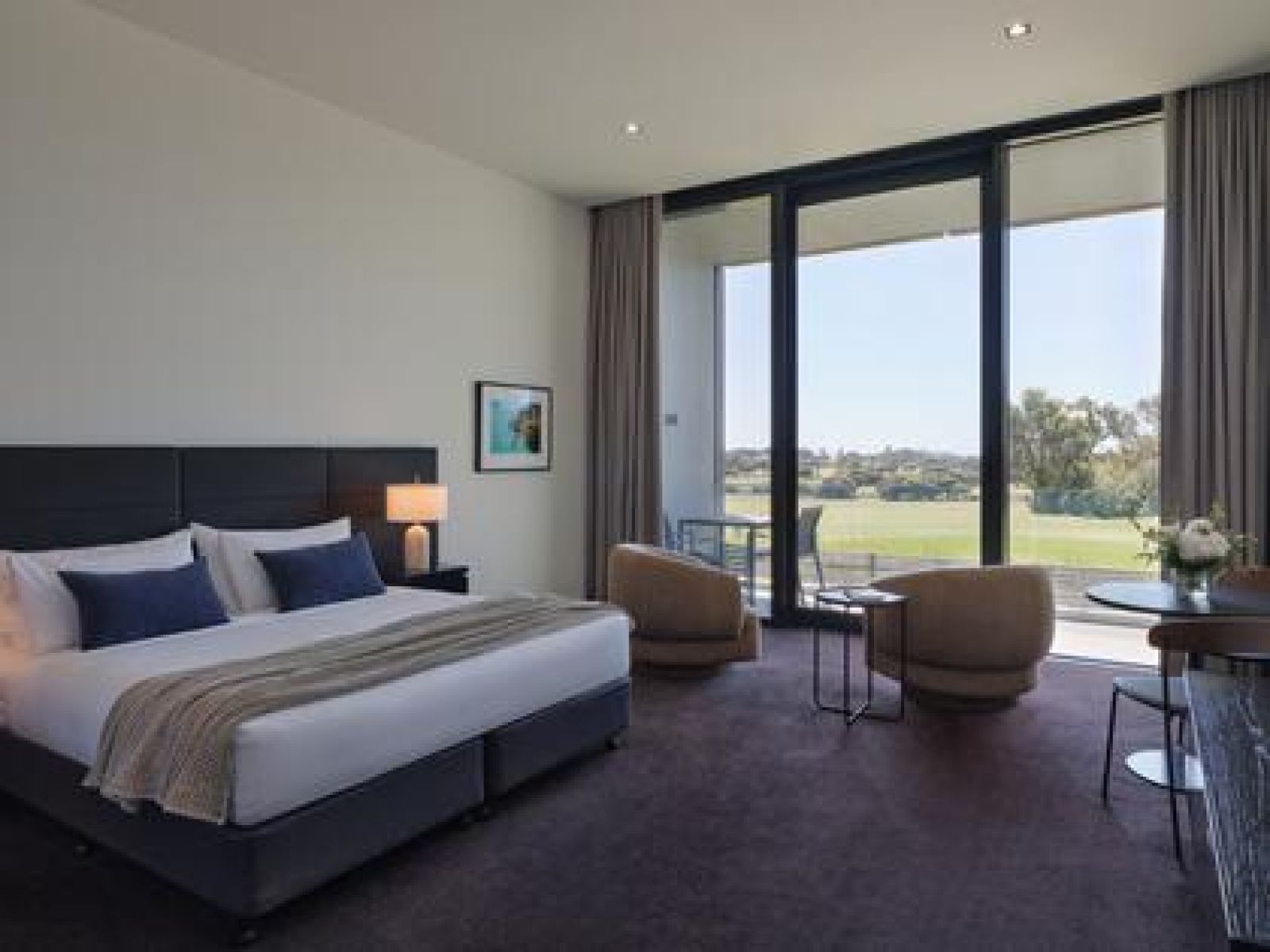 Golf view room at RACV Torquay Resort, featuring a king bed, couches and desk.