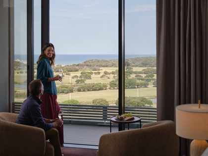 A couple enjoying a glass of wine with the view from a premium mountain room at RACV Healesville.