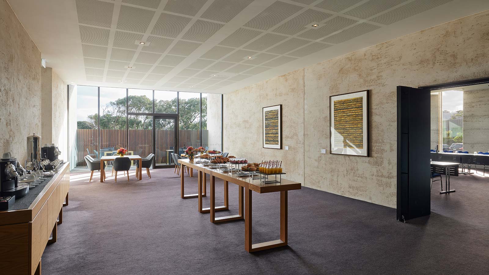Tables lined with food in RACV Torquay Resort's Bells 1 room, including a tea and coffee station, donuts and canapes.