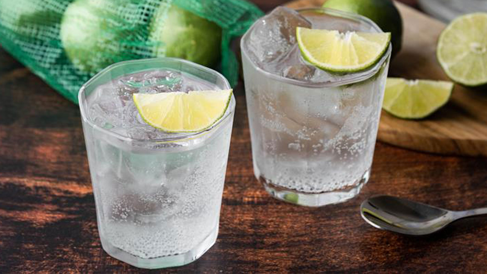 Two glasses of Gin topped with fresh lime wedges