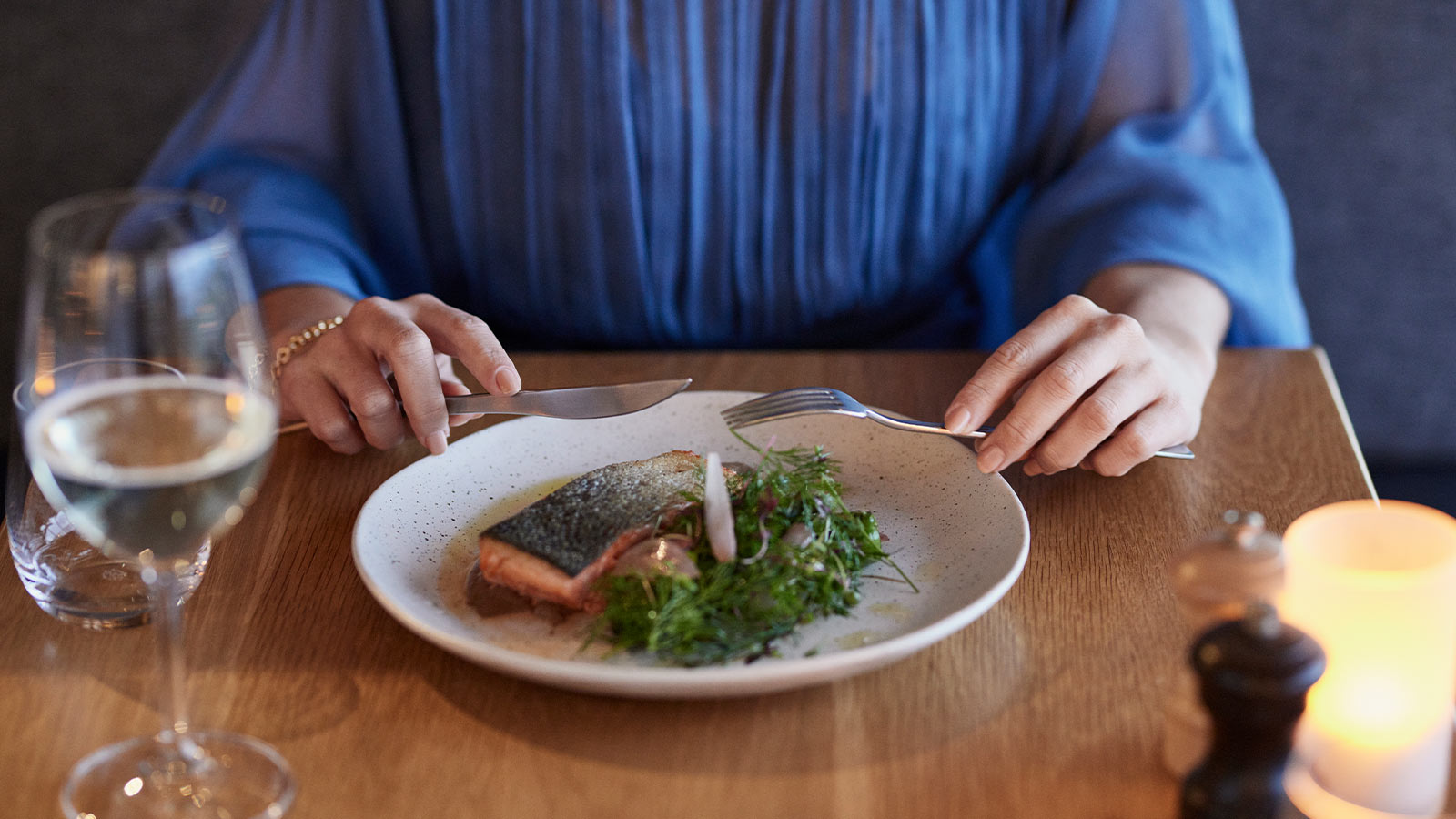 Person eating a salmon dish at RACV Torquay Resort's Number One restaurant.