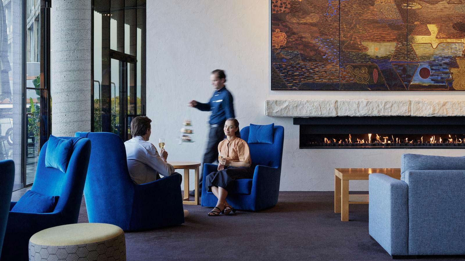 Couple having wine while waiter brings afternoon tea food at RACV Torquay Resort Harding's Lounge.