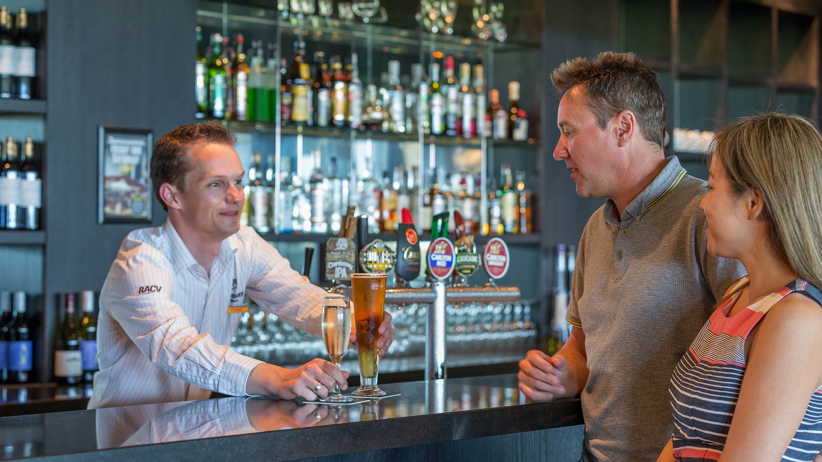 Bartender serving couple drinks at White's Paddock restaurant at RACV Torquay Resort.