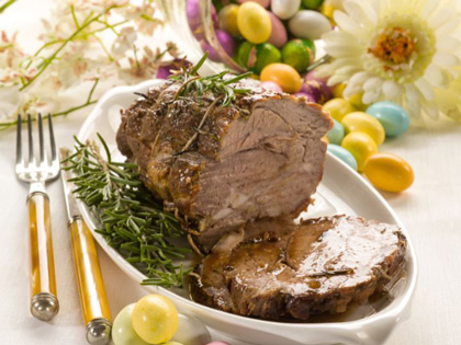 A carved roast beef topped with rosemary. 