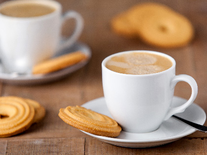Mugs of coffee with biscuts. 