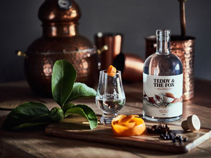 A table with a bottle of gin and garnishes. 