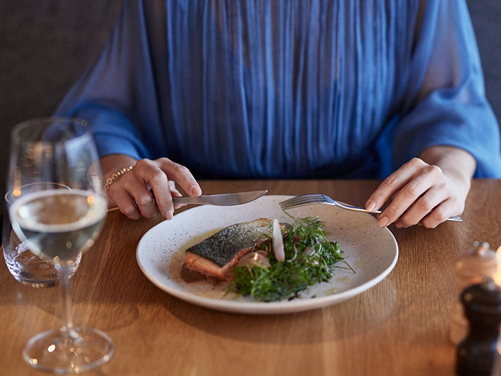 Person eating a salmon dish at RACV Torquay Resort's Number One restaurant.