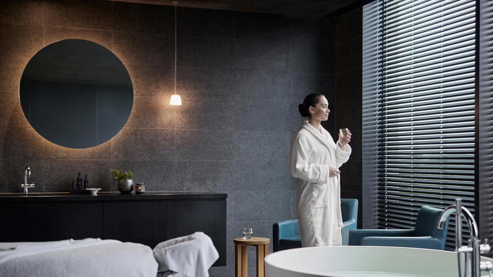 Person standing having a glass of water in treatment room at RACV Torquay One Spa.