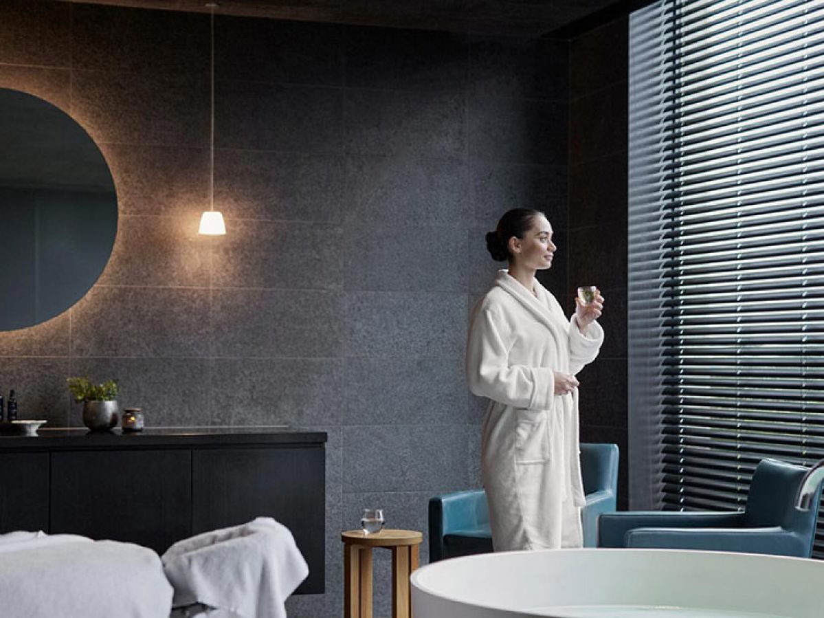 Person standing having a glass of water in treatment room at RACV Torquay One Spa.
