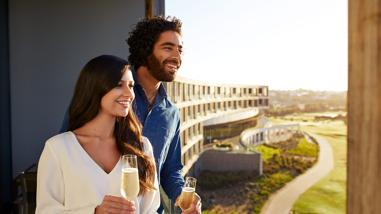Couple drinking champagne on their room's balcony at RACV Torquay Resort.