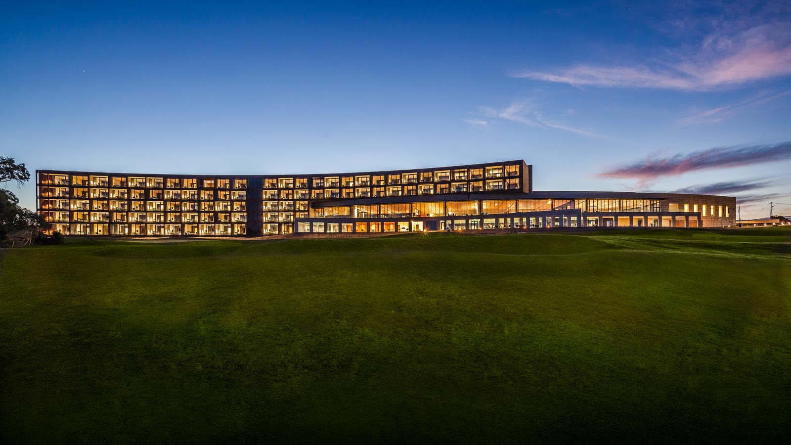 Exterior of building with lights on at dusk at RACV Torquay Resort.