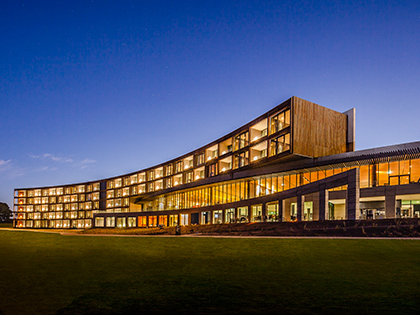 Exterior of RACV Torquay Resort, lit up in the evening.