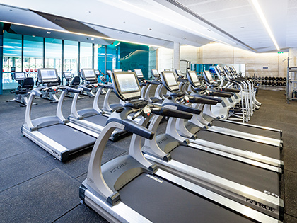 Rows of treadmills facing the indoor pool at RACV Torquay Resort's One Lifestyle fitness centre.