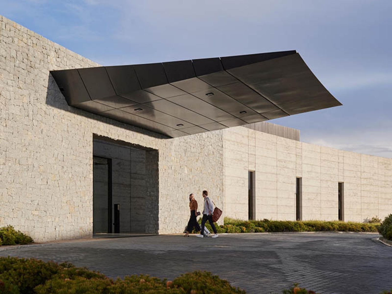 Couple walking up to RACV Torquay Resort's front entrance.