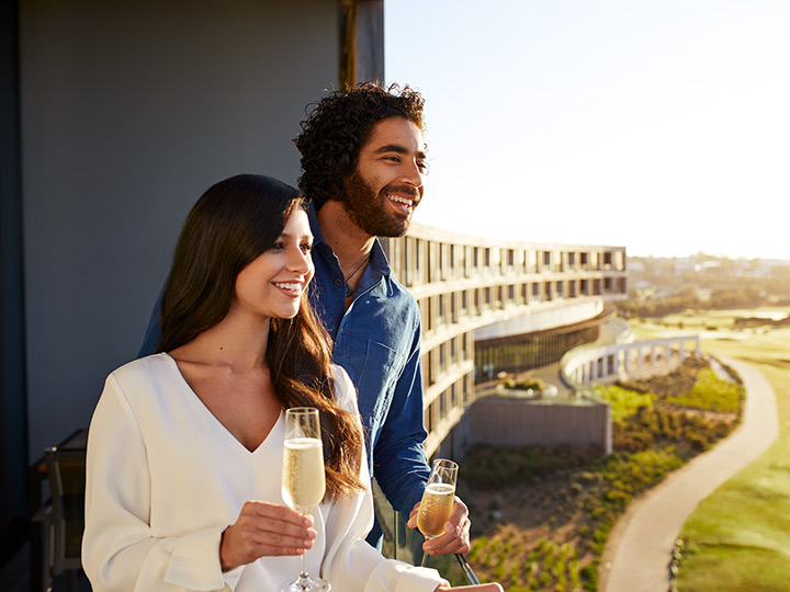 Couple drinking champagne on their room's balcony at RACV Torquay Resort.