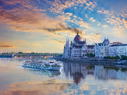 Castles on the edge of a river with a river boat going past.