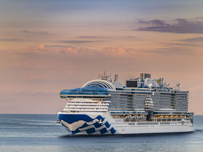 The Sky Princess cruise ship at dusk out in the ocean. 