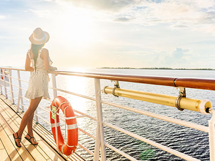 Women on the balcony of a cruise ship at sunset.