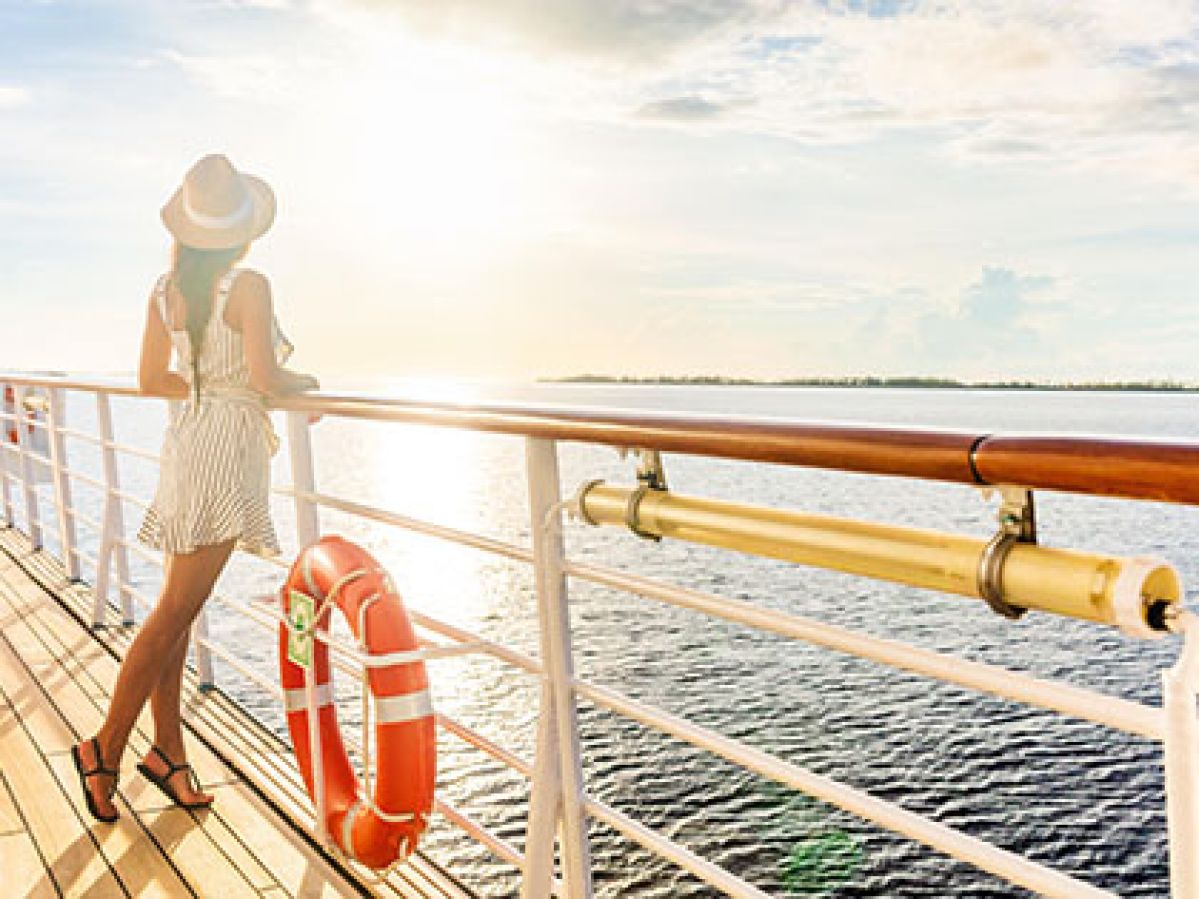 Women on the balcony of a cruise ship at sunset.