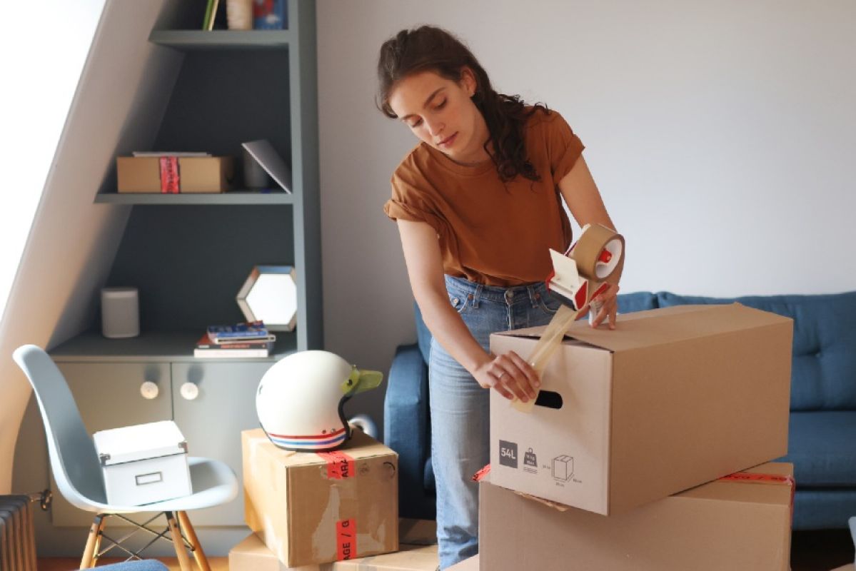 woman packing a box to move house