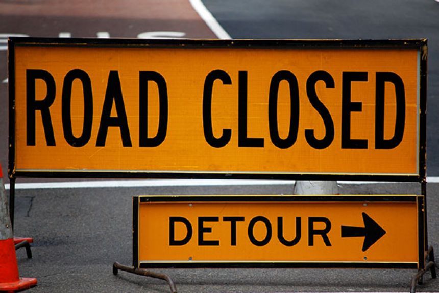 Road closed and detour signs point for traffic