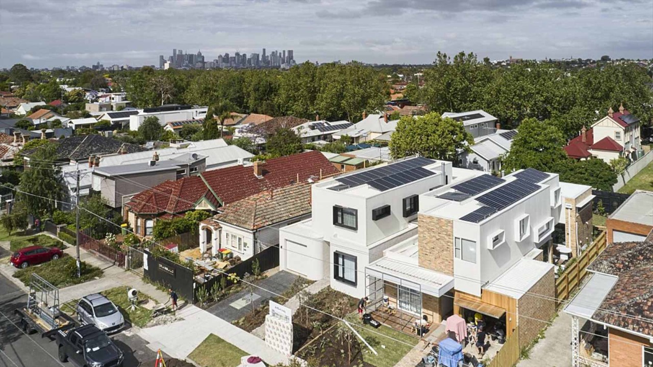 Exterior view of Fairfield House fitted with solar panels, with the Melbourne CBD cityscape in the background.