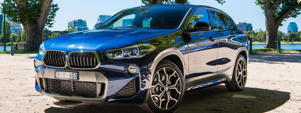 Front view of BMW X2 parked in front of a lake