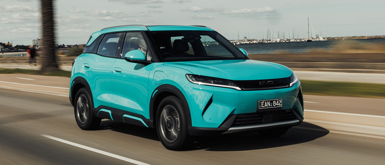 A turquoise blue BYD Atto 2 DM-I drives down Melbourne's Beaconsfield Pde