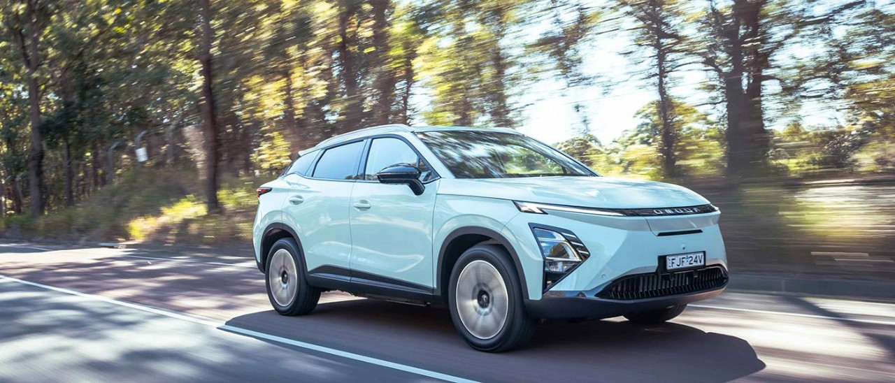Blue Chery Omoda driving along a country road.