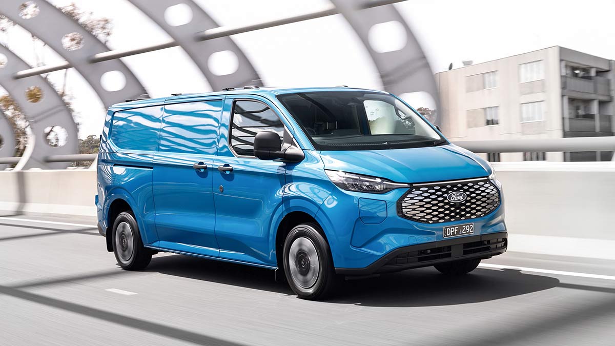 Blue Ford E-Transit Custom van on Tullamarine Freeway in Melbourne approaching Bolte Bridge.